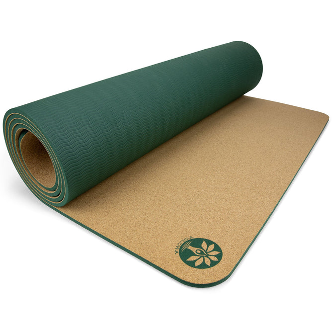 The Aura Cork Yoga Mat by Yoloha Yoga is partially rolled out on a white surface, displaying its comfortable cork surface and a flower logo in one corner, with green cushioning underneath.