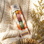 The Bath Bomb Set - Autumn Heirlooms Collection by Pacha Soap Co. rests on a chunky knit blanket beside dried yellow flowers in a woven basket, bathed in warm sunlight and ready to fill your space with a cozy fall fragrance.