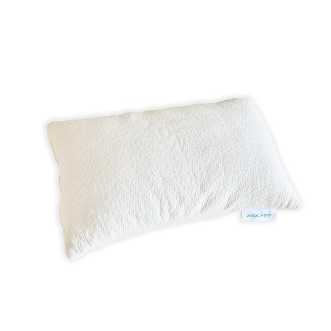 The Avocado Toddler Pillow, featuring a rectangular white design with a textured surface and a fabric tag labeled "Avocado," is displayed against a plain white background.