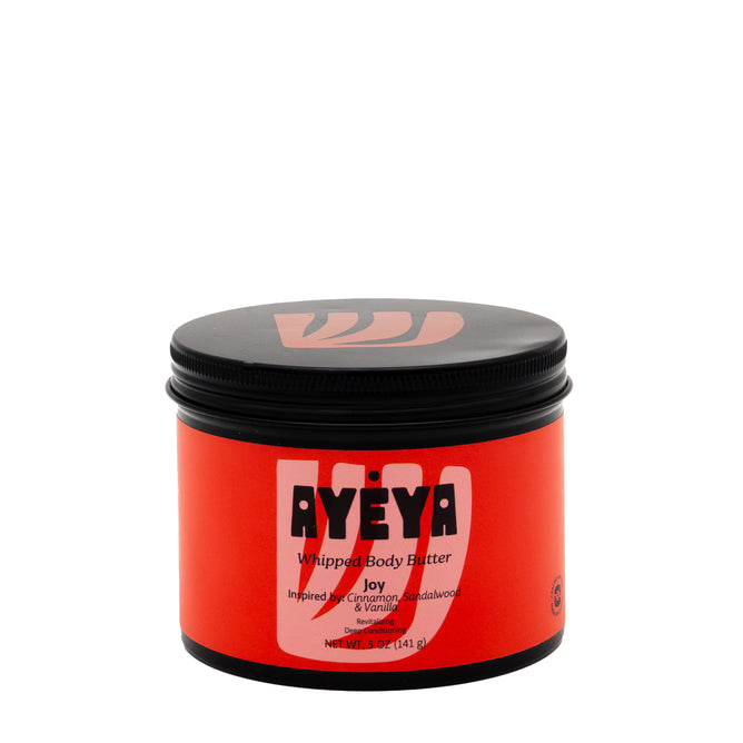 A 5 oz (141 g) red jar of Ayeya Whipped Body Butter in Joy, inspired by cinnamon, sandalwood, and vanilla, features a black screw-on lid and delivers rich hydration to deeply nourish your skin.