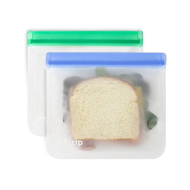 The (re)zip Flat Sandwich Bags are reusable PEVA lunch bags with green and blue zippers. Their semi-transparent design lets you see your sandwiches inside, while the leakproof seal keeps your food fresh and secure.