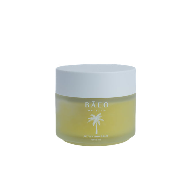 Baeo Bare Butter - Hydrating Balm comes in a frosted glass jar with a white lid. Its label shows a palm tree and text on a plain white background. Formulated for sensitive skin with hydrating avocado and olive oils.