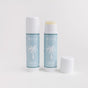 Two light blue Baeo Bare Face - Soothing Face Sticks, perfect for sensitive skin, are displayed on a white background—one capped, one uncapped. The label features a white palm tree illustration.