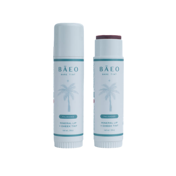 Two tubes of Baeo Bare Tint - Mineral Lip + Cheek Tint: one closed, one open to show the mineral tint. Both have a nourishing formula and white packaging with teal palm tree designs.