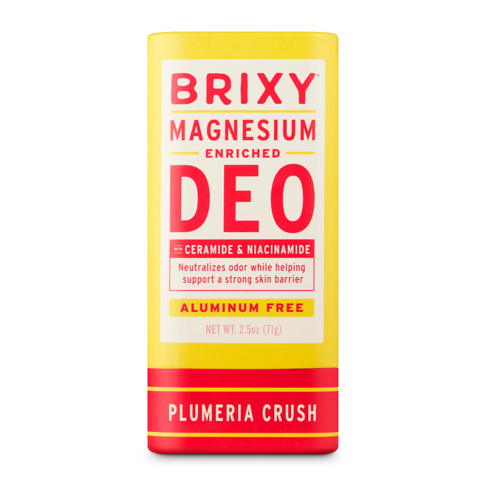 A yellow and red BRIXY Deodorant tube in Plumeria Crush scent, enriched with magnesium, ceramide, and niacinamide for sensitive skin. Aluminum free, odor neutralizing, skin supporting, and zero plastic packaging.