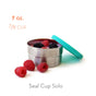 The EcoLunchBox Seal Cup Solo is a small, plastic-free stainless steel food container with a teal lid, shown partially open and filled with berries. Three raspberries sit in front. Text: 7 oz., 7/8 cup, and Seal Cup Solo.