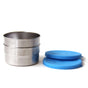 Two round EcoLunchBox Seal Cup Medium stainless steel containers are stacked next to two blue silicone lids on a white background. These leak-proof, plastic-free lunchbox containers offer flat-fitting lids beside them.