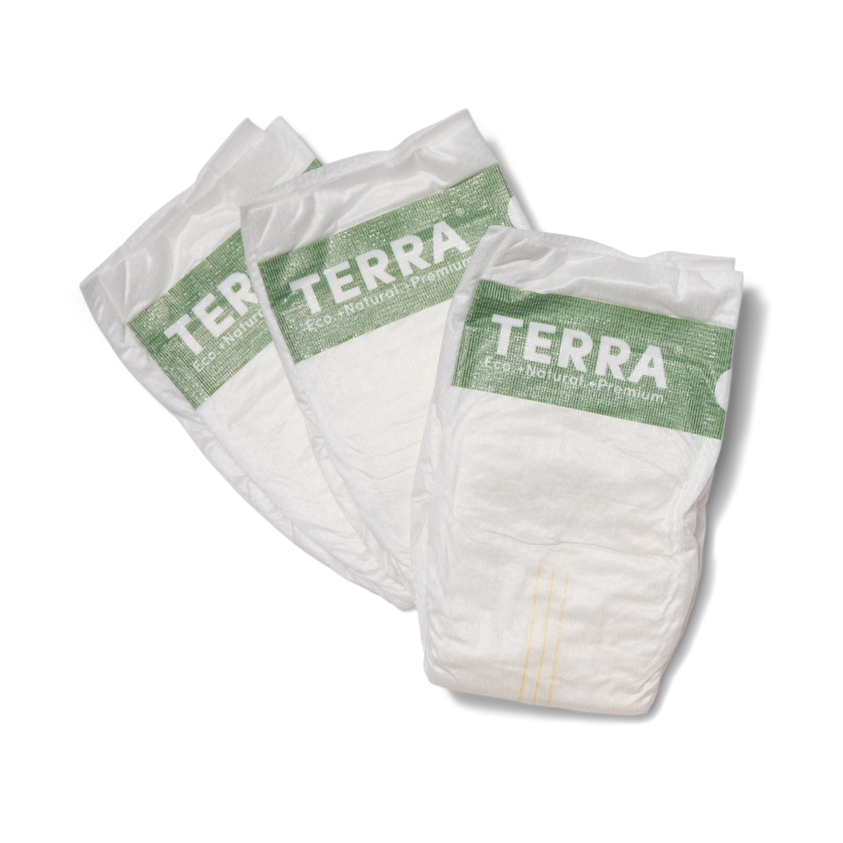 Three white disposable diapers with green labels reading TERRA Eco. Natural. Premium are arranged side by side on a white background.