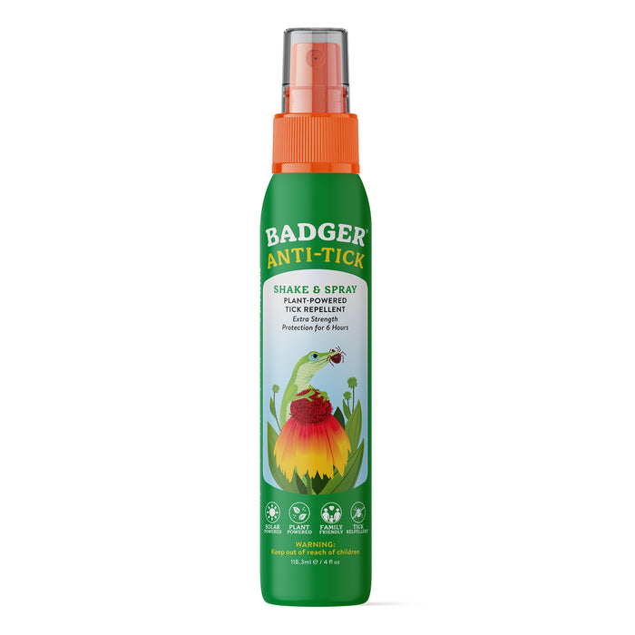 A green spray bottle labeled Badger Balm Anti-Tick Repellent Shake & Spray, featuring an illustration of a badger and a flower. The label highlights its organic, plant-powered formula for extra-strength tick protection lasting up to 8 hours, and proudly states that it is DEET-free.