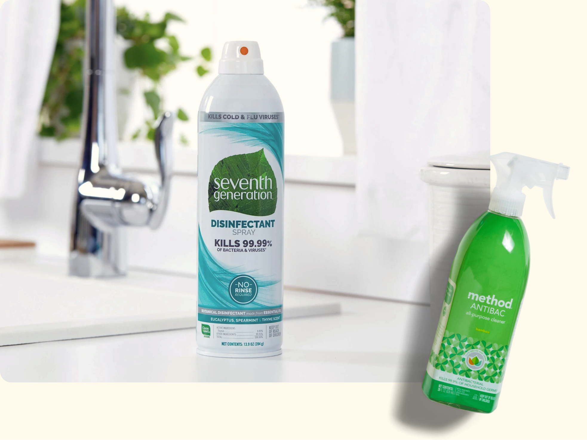 Two green cleaning product bottles, one Seventh Generation disinfectant spray on a kitchen counter near a sink, and one Method Antibac spray bottle on a light surface.