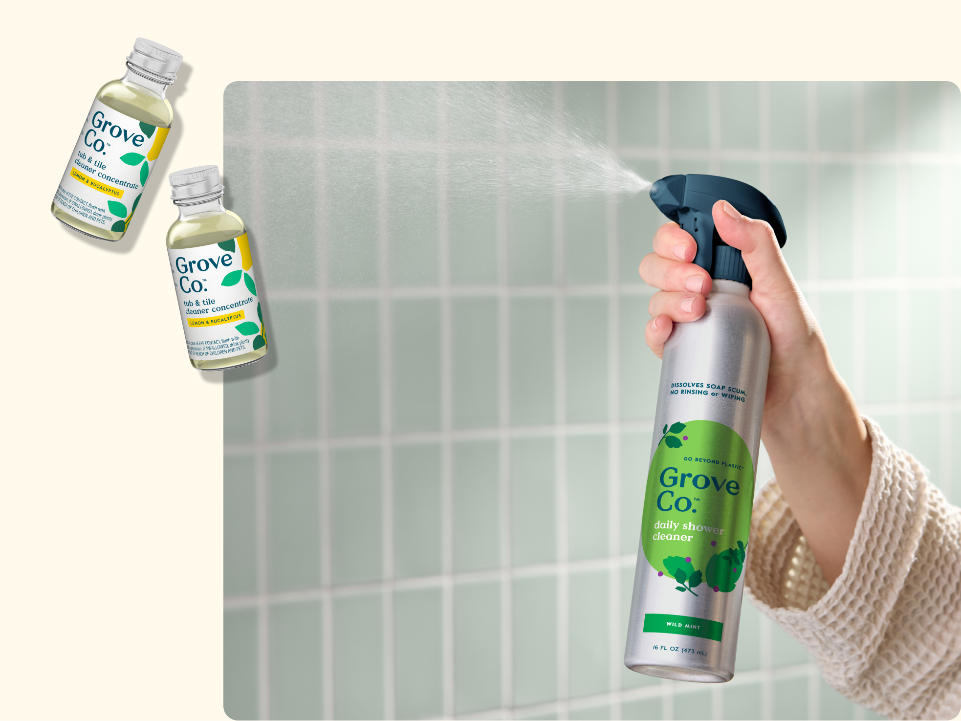 A hand sprays Grove Co. daily shower cleaner in a silver bottle, with two small bottles of Grove Co. cleaning concentrates floating nearby, all set against a light green tiled background.