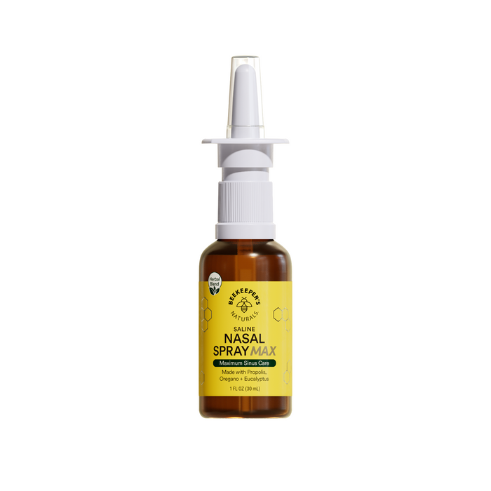 A brown bottle of Beekeepers Naturals Nasal Spray Max with a white spray nozzle and a yellow label featuring honeycomb graphics, product details, and key ingredients like propolis and xylitol.
