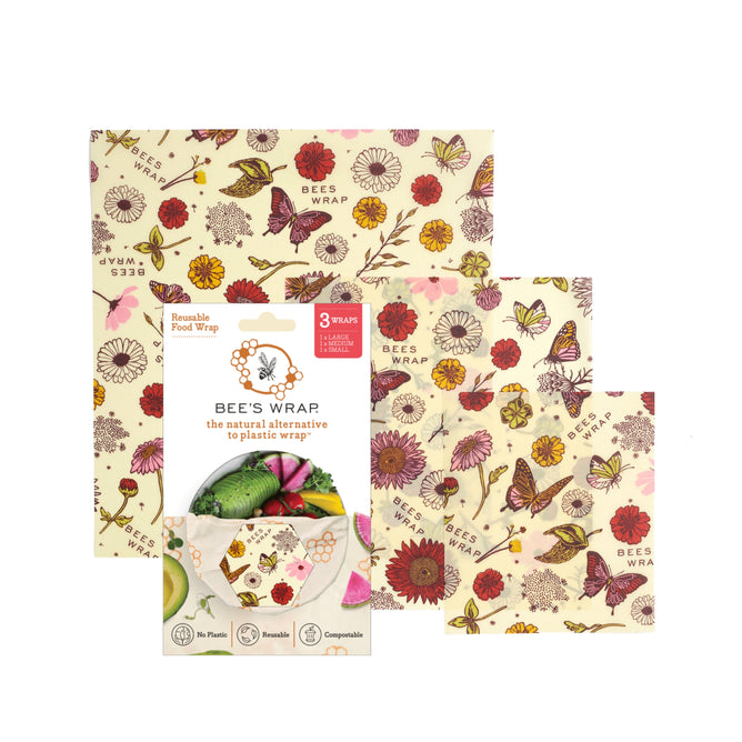 Bee's Wrap Reusable Beeswax Food Wraps – Assorted 3 Pack features floral and butterfly designs, shown beside packaging that emphasizes eco-friendly, plastic-free, and compostable benefits for sustainable food storage.