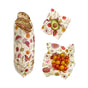 Bread, half an avocado, and red/yellow cherry tomatoes are wrapped in Bee's Wrap Reusable Beeswax Food Wraps – Assorted 3 Pack for sustainable storage, shown with colorful flower and bee patterns on a white background.