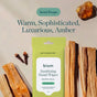 A yellow Biom Hand Sanitizing Wipe Go-Pack in the Santal Escape scent rests on a tan surface, surrounded by sandalwood sticks, cloves, and amber resin. These plant-based alcohol wipes offer a warm, sophisticated, and luxurious amber experience—ideal as travel-sized hand sanitizing wipes for use on the go. Text reads: Warm, Sophisticated, Luxurious, Amber.
