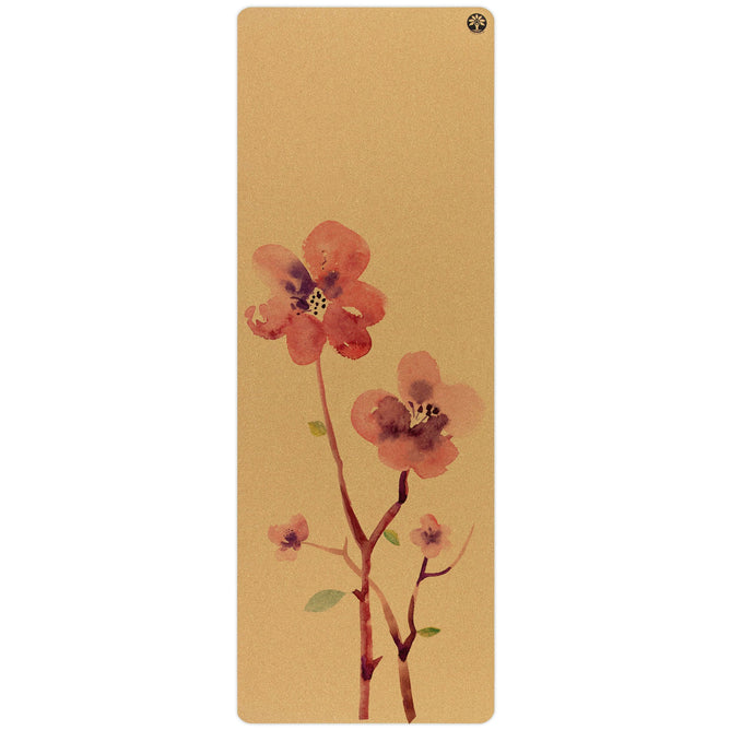 The Blossom Aura Cork Yoga Mat by Yoloha Yoga is a beige cushioned mat featuring a watercolor design of three pink flowers with green stems and leaves near the center.