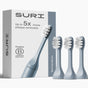 A box labeled SURI and 3x SURI Brush Replacement Heads stands next to four light blue recyclable toothbrush heads. The box also shows a Certified B Corporation logo and the words Morning Waves.