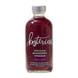 A glass bottle of Kosterina Crushed Blueberry Vinegar features dark purple vinegar with a silver cap. The label highlights its use in dressings and cocktails, with no added sugar or artificial flavors.