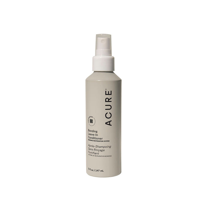 A white Acure Bonding Leave-in Conditioner spray bottle, 5 fl oz (147 mL), with black label text and coconut oil, stands upright against a plain white background.