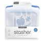 Stasher Reusable Silicone Sandwich Bag 2-pack in blue, shown in packaging with apple, pencil, and puzzle icons. Label notes “set of 2,” dishwasher safe design, easy open seal, and reduces single-use plastic.