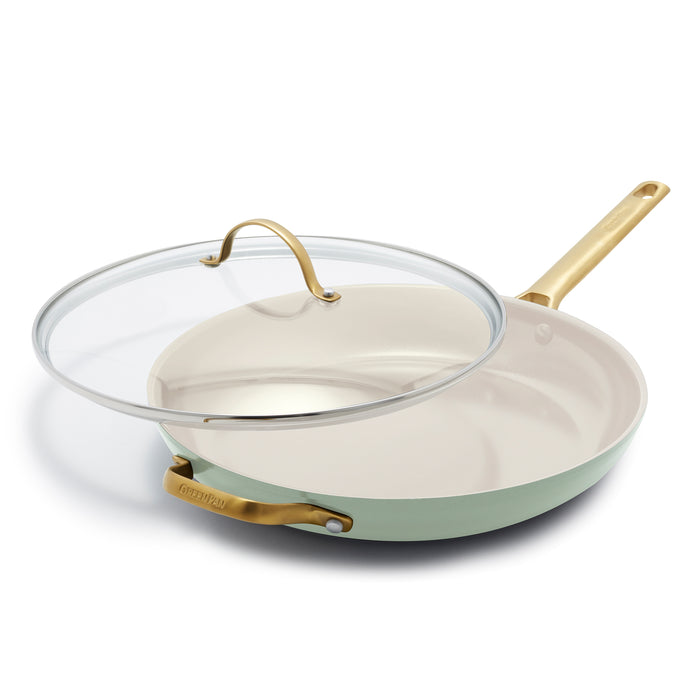 The GreenPan Reserve Ceramic Nonstick Fry Pan with Lid, 12 in Julep, features a light green finish, beige interior, stylish gold handles, and a clear glass lid. This PFAS-free pan combines safety and elegance for your kitchen.