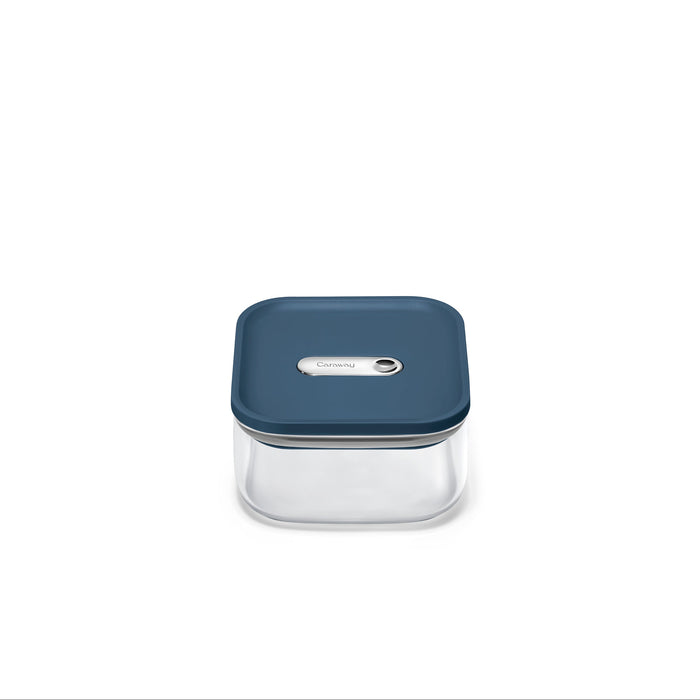 The Caraway Glass Small Container, 1 qt, features non-toxic glass with a dark blue button-seal lid. Its transparent square design is set against a plain white background.