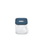 The Caraway Glass Medium Container, 2.5 qt, has a clear glass body with a teal blue lid and central silver button—ideal for non-toxic food storage and pantry organization, shown on a plain white background.