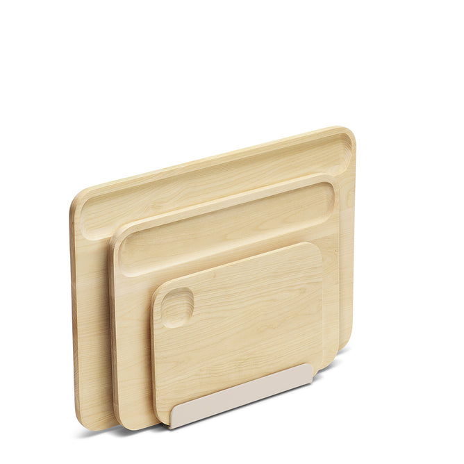Three Caraway Birch Wood Boards of varying sizes, made from FSC-certified birch and featuring recessed handle grooves, stand upright in a white holder against a plain background.