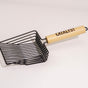 The Catalyst Pet Wide Slatted Litter Scoop features a durable black, square, wide-slatted basket and a light wooden handle labeled CATALYST, shown resting on a light surface.