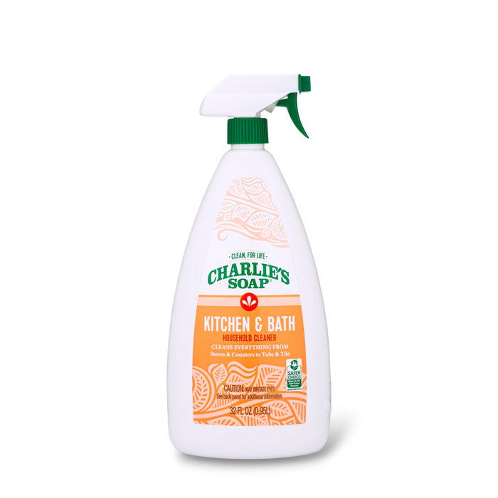A white spray bottle labeled Charlie's Soap Kitchen & Bath Household Surface Cleaner with orange and green accents is set against a plain white background—an effective household cleaner for kitchens and bathrooms.