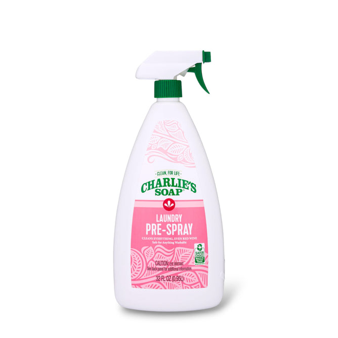 A white spray bottle of Charlie's Soap Laundry Pre-Spray Stain Remover with a green nozzle and pink label is shown on a white background. The label highlights its cleaning power and effectiveness for fabric stain removal.