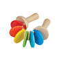 The PlanToys Wooden Clatter Toy is a sustainable musical instrument for toddlers, featuring two handles and fan-shaped, colorful discs in red, yellow, green, and blue.