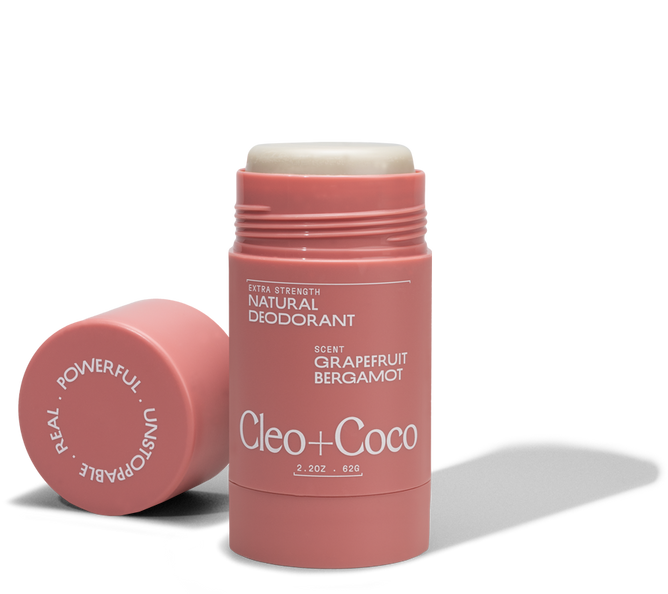 A pink tube of Cleo & Coco Extra Strength Deodorant in grapefruit bergamot scent, cap off and beside it. The aluminum-free label highlights strong odor-fighting ingredients for long-lasting freshness.