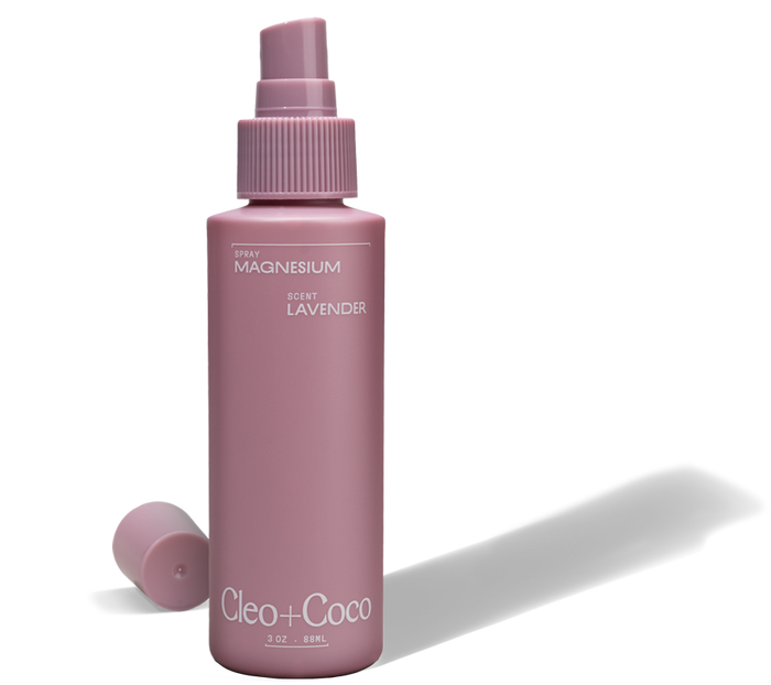 A mauve Cleo & Coco Magnesium Spray bottle with a lavender scent, cap off beside it, highlights essential minerals for effortless odor protection.