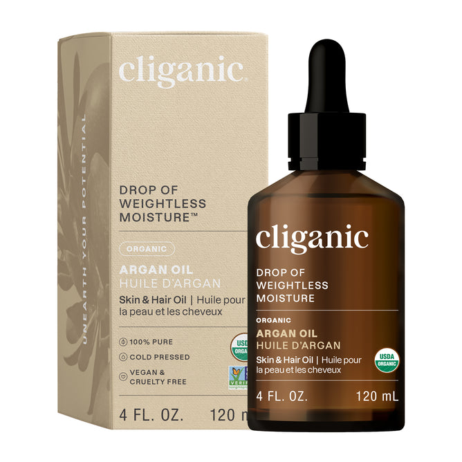 A brown glass bottle of Cliganic Organic Argan Oil with a black dropper cap is displayed beside its beige box. The label highlights its use for skin and hair, and notes it is vegan, cold-pressed, and USDA organic.