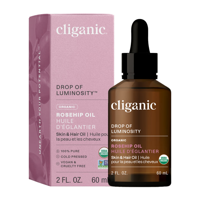 A bottle of Cliganic Organic Rosehip Oil with a dropper stands next to its pink box. The label notes this 100% pure, vegan, and cruelty-free oil is a natural skin and hair moisturizer.