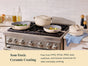 Three cream-colored ceramic cookware pieces sit on a stainless steel stove in a modern kitchen. Text reads: Non-Toxic Ceramic Coating. Free from PTFE, PFOA, PFAS, lead, cadmium, and forever chemicals for safer everyday cooking.