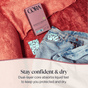 A box of Cora Got-You-Covered Pantyliners – Light Absorbency sits on a pink couch beside a pair of blue jeans with a pantyliner inside. Text below reads, “Stay confident & dry. Our breathable liner and dual-layer core absorb liquid fast to keep you protected and dry.”.