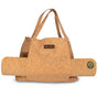 The Yoloha Yoga Cork Tote Bag is a stylish tan cork yoga mat holder designed as a tote with two handles. It neatly carries a matching cork yoga mat, which features a green flower logo near one end. A small patch with the Yoloha name adds a distinctive touch, making this Cork Tote Bag an ideal companion for your daily practice.