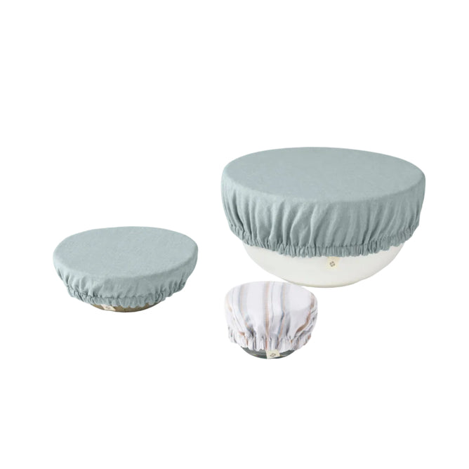 Three bowls of varying sizes, each topped with Coyuchi’s Conserve Organic Bowl Covers in pastel hues, rest on a white background—an ideal zero-waste kitchen upgrade.