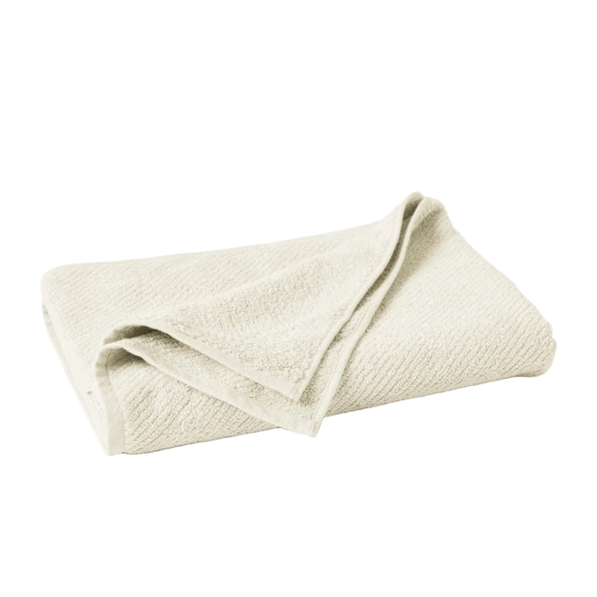 The Coyuchi Organic Bath Towel from the Air Weight Collection is neatly folded on a white background, showcasing its light beige color and soft textured absorbency with one corner draped over the rest.