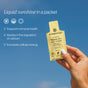 A hand holds a yellow packet of Cymbiotika Liposomal Vitamin D3 + K2 + CoQ10 against a blue sky, with text highlighting health benefits: immune support, calcium regulation from Vitamin K2, and enhanced cellular energy.