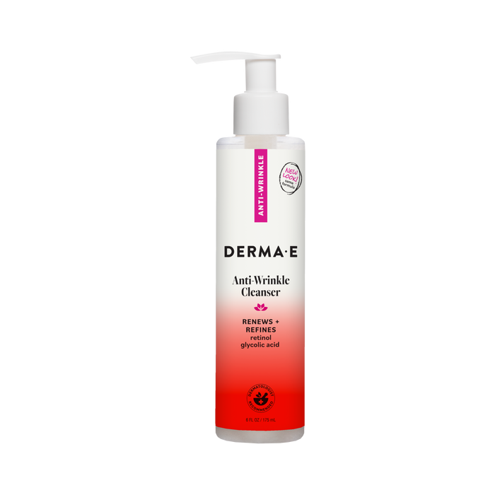 A bottle of Derma E Anti-Wrinkle Cleanser with a white pump, featuring powerful ingredients such as retinol and glycolic acid, comes in white and pink packaging labeled “Renews + Refines.”.