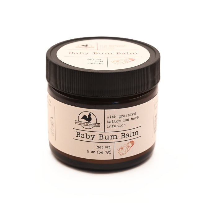 Hearth and Homestead Baby Bum Balm comes in a 2 oz (56.7 g) jar with a beige label and black lid. Made with grassfed tallow and herb infusion, this natural balm helps soothe diaper rash gently.