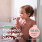 A young child in pink pajamas sits on the floor brushing their teeth with a purple toothbrush. Text reads: “ATTITUDE baby leaves Training Toothpaste—fluoride-free, 98.8% natural origin*, for good dental habits.”.