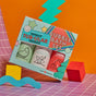 The Totally Tubular Bubble Bath Set by Dabble & Dollop is a vibrant holiday gift with three bottles—Ode to Mint, All Natural Vanilla Whip, and All Natural Strawberry—on geometric packaging. Gentle formulas suit sensitive skin.