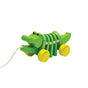 The Dancing Alligator Pull Toy for Toddlers by PlanToys is a green wooden pull-along toy with yellow wheels, moving segments, and cartoon eyes—a sustainable, eco-friendly choice for endless toddler fun.