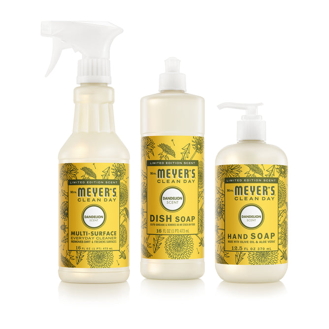 Three Mrs. Meyer's Summer Cleaning Set – Home Essentials products in yellow bottles are shown: Multi-Surface Cleaner spray, Dish Soap pump, and Hand Soap pump, each labeled "Dandelion Scent" with floral designs.