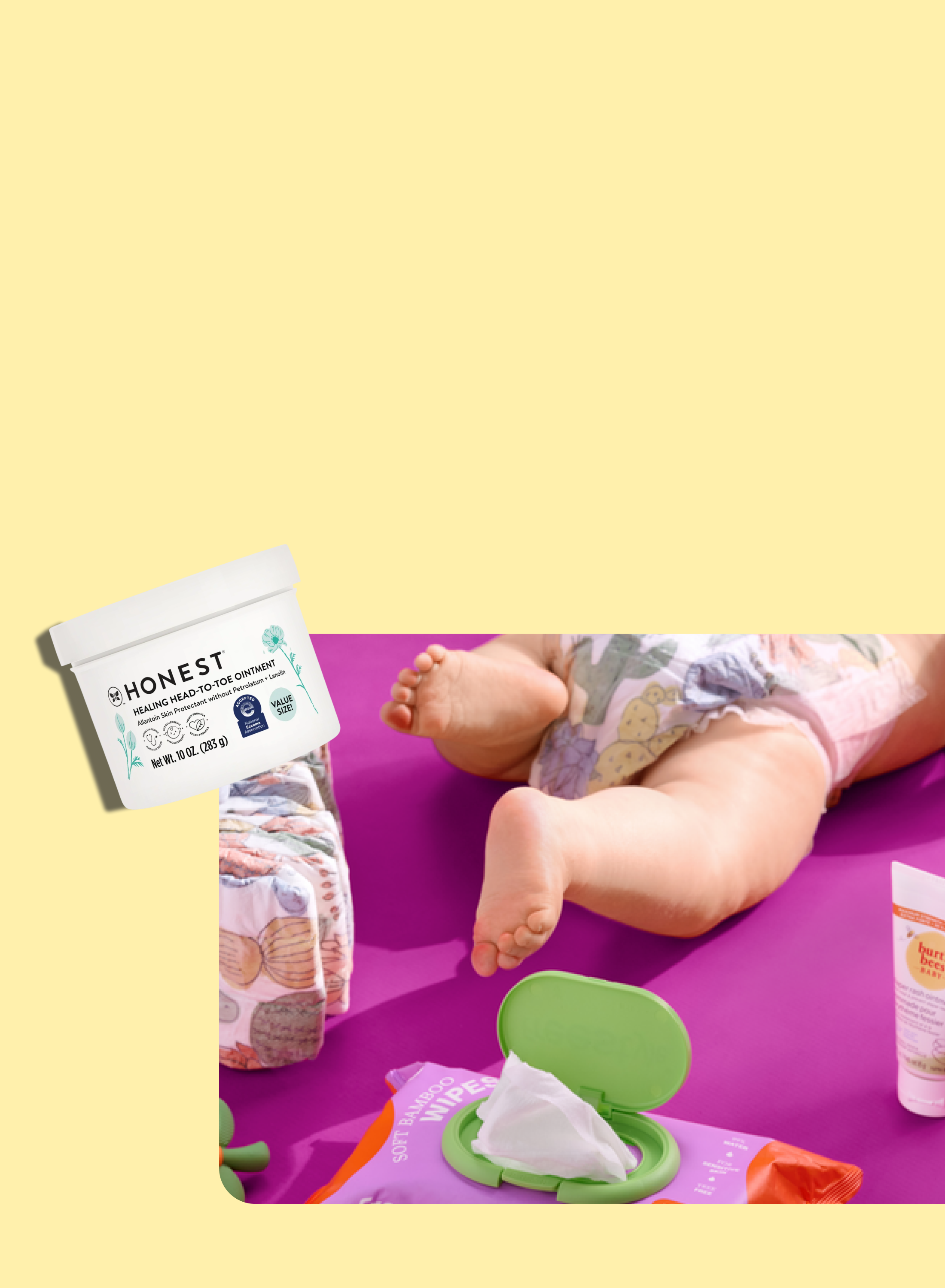 A baby in a diaper lies on a purple surface with wipes, cream, and a diaper nearby. A container of Honest diaper rash cream is shown in the upper left corner on a yellow background.
