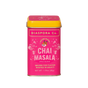 A rectangular tin of Diaspora Spice Co. Chai Masala features a bright pink label and yellow lid, showcasing “House Blend Chai Masala” made from single-origin spices grown for flavor and equity.